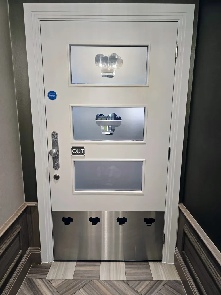 White door with vision panels and metal kick plate in a corridor with wall panelling