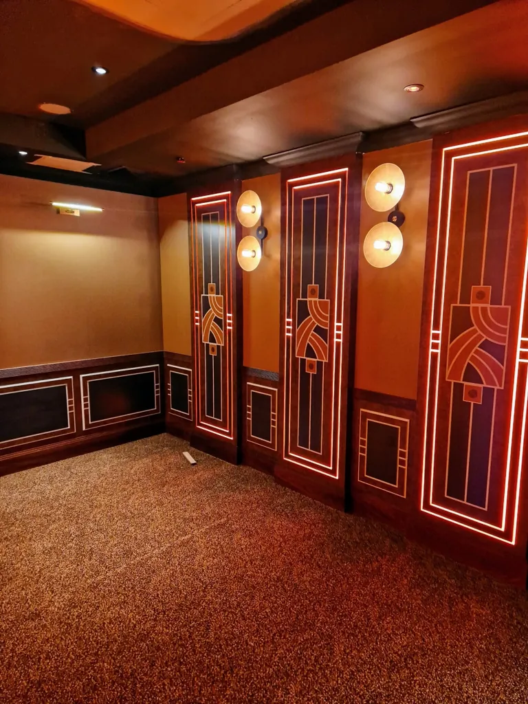 Decorative corridor with illuminated wall panels featuring geometric designs and carpet flooring